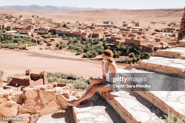 woman enjoying view on steps, ouarzazate, souss-massa-draa, morocco - morocco tourist stock pictures, royalty-free photos & images