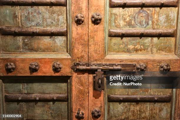 Detail of traditional woodwork and metalwork are showcased on wooden doors carved with intricate patterns and designs on display in Mumbai,...