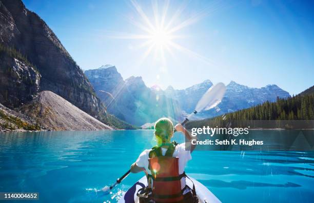 mid adult woman kayaking, moraine lake, alberta, canada - rocky mountains stockfoto's en -beelden