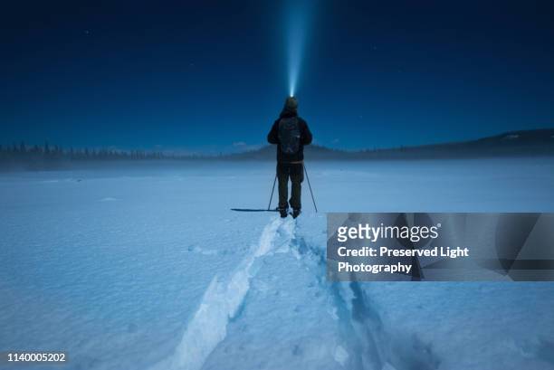 man cross country skiing in moonlight, carmi cross country ski loop, penticton, british columbia, canada - nordic skiing event fotografías e imágenes de stock