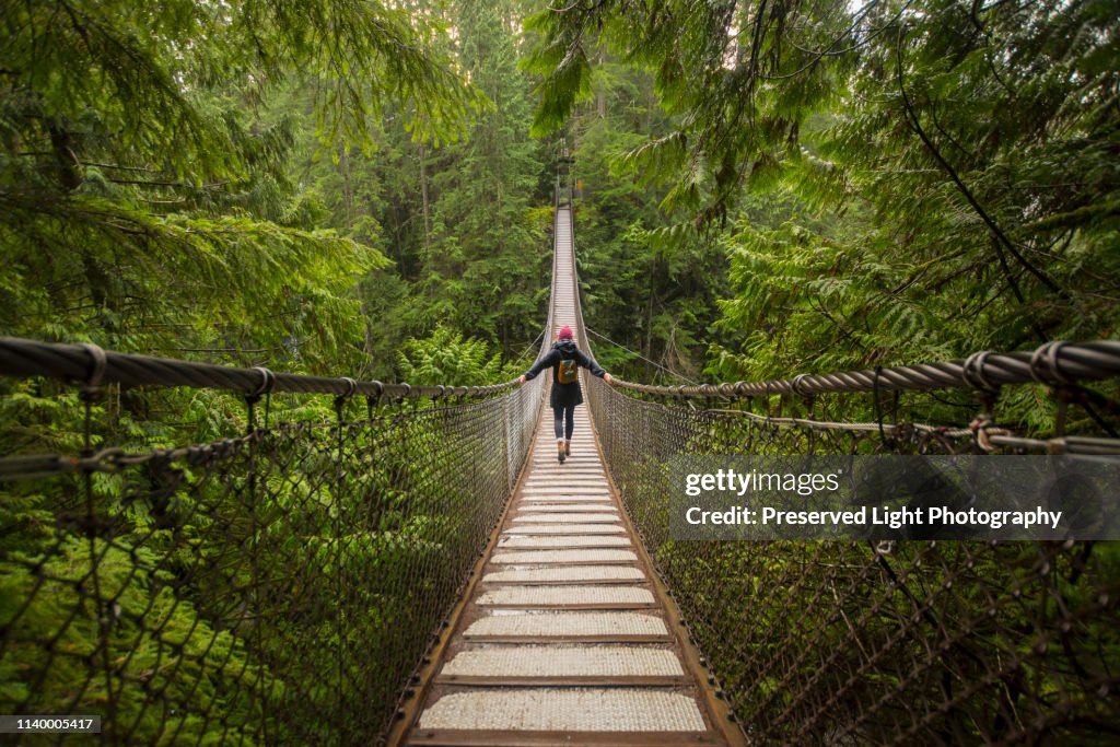 Woman on Lynn canyon suspension bridge, North Vancouver, British Columbia, Canada