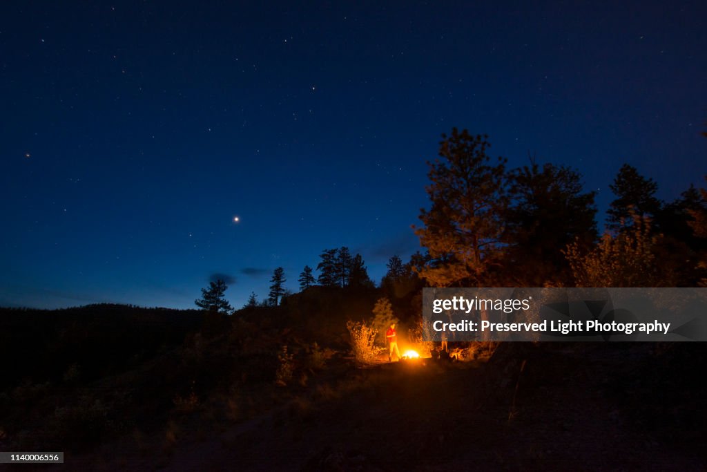 Friends round campfire, Pincushion Mountain, Peachland, British Columbia, Canada