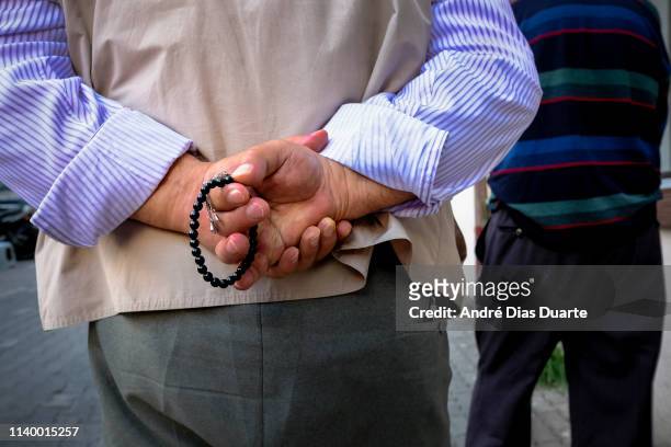 man with a masbaha on his hands while walking down the street - bead string stock pictures, royalty-free photos & images