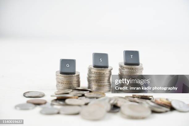 stack coins and gst button - gst bildbanksfoton och bilder