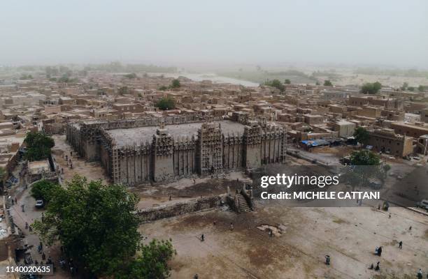 Picture shows the Great Mosque of Djenne in central Mali during its annual rendering ceremony on April 28, 2019. - Several thousand residents of the...