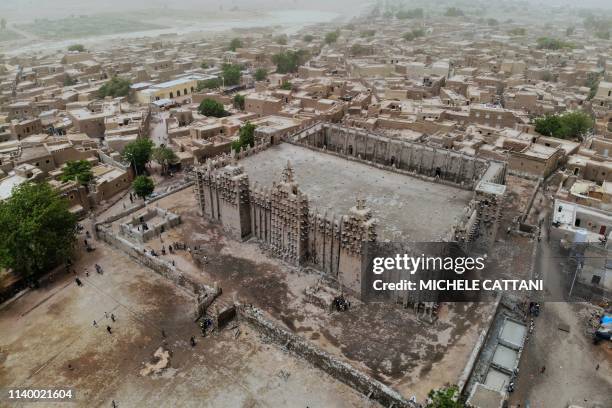 Picture shows the Great Mosque of Djenne in central Mali during its annual rendering ceremony on April 28, 2019. - Several thousand residents of the...