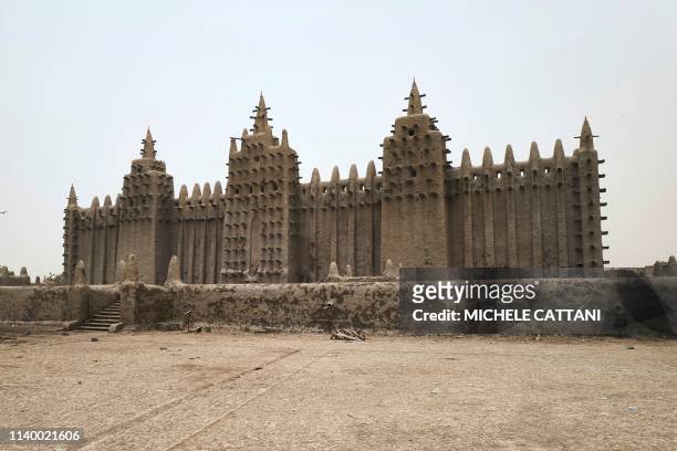 Picture shows the Great Mosque of Djenne in central Mali during its annual rendering ceremony on April 28, 2019. - Several thousand residents of the...
