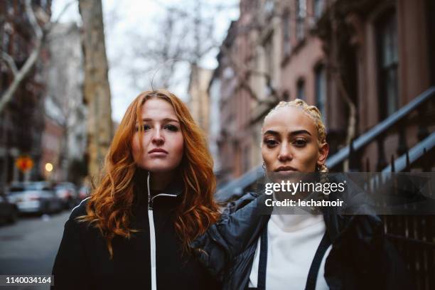 modieuze, jonge vrouwen met expressieve houding in lower manhattan, new york - the bronx stockfoto's en -beelden