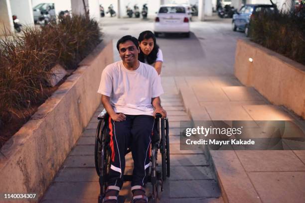 woman assisting her handicaped brother in a wheelchair - sister stock pictures, royalty-free photos & images