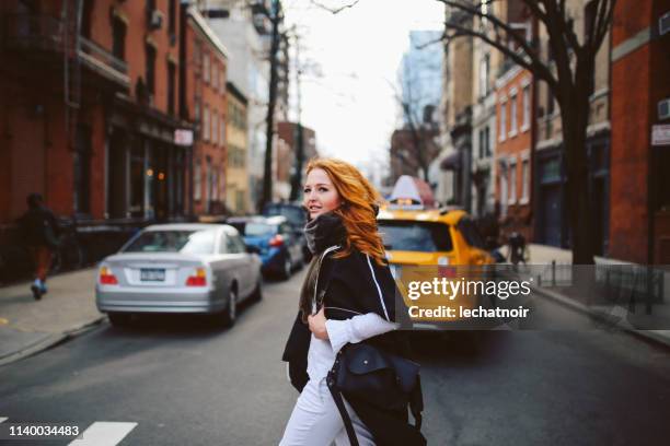 young redhead woman walking on the streets of west village, manhattan, ny - one manhattan west stock pictures, royalty-free photos & images