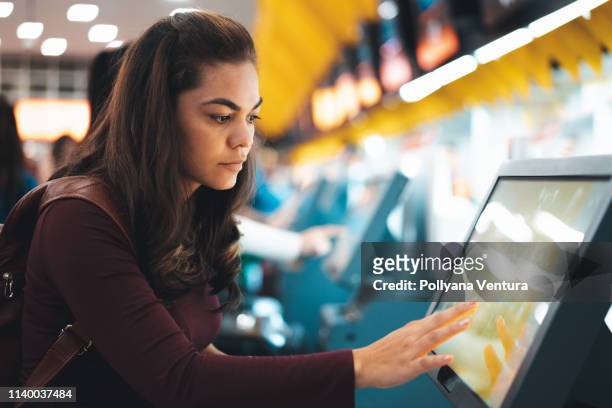 mujer haciendo check-in para vuelo en el aeropuerto - vestíbulo edificio de transporte fotografías e imágenes de stock