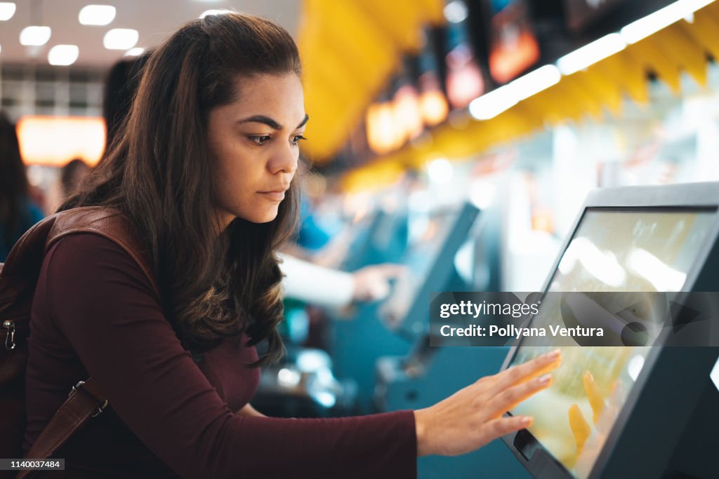 Woman doing check-in for flight at airport