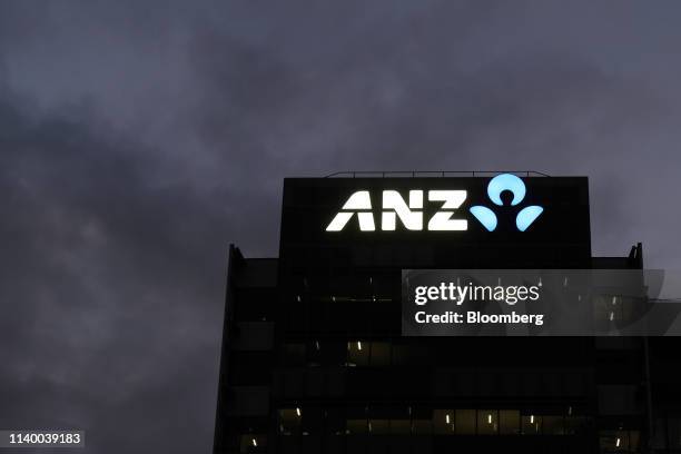 The Australia and New Zealand Banking Group Ltd. Logo is illuminated atop the headquarters building at dusk in Melbourne, Australia, on Friday, April...