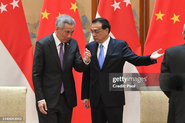 Singapore's Prime Minister Lee Hsien Loong, left, is shown the way by Chinese Premier Li Keqiang, after a signing ceremony on April 29, 2019 at the...