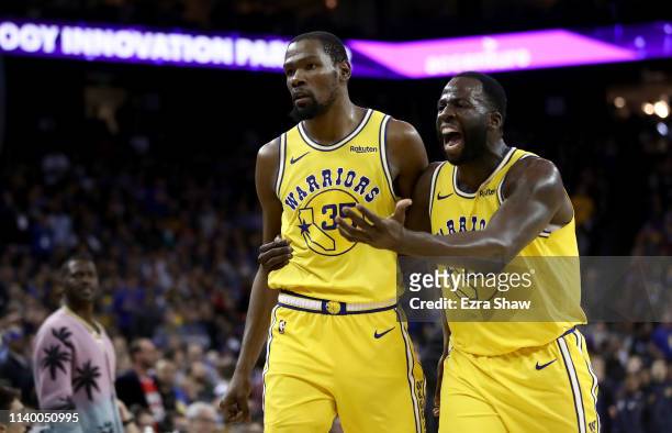 Kevin Durant of the Golden State Warriors is escorted off the court by Draymond Green after Durant was ejected from the game for complaining about a...