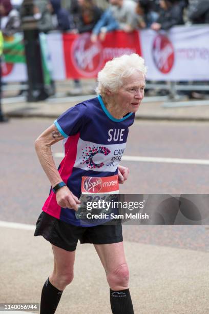 An elderly woman running for Cancer Research UK charity at Birdcage Walk during The Virgin London Marathon on 28th April 2019 in London in the United...