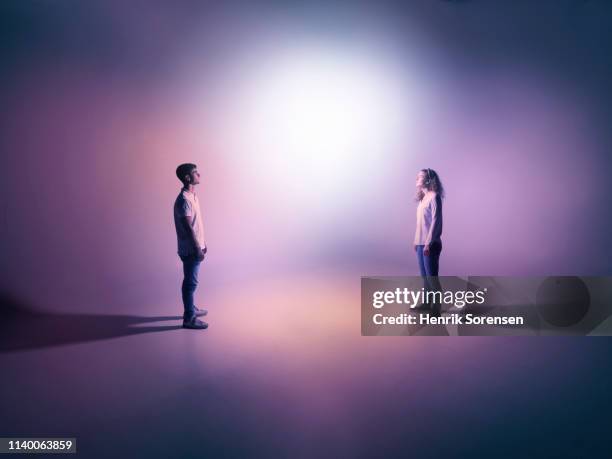young pair looking at light - face à face photos et images de collection