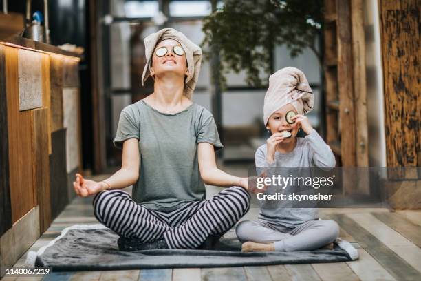 la mère et la fille détendues exerçant le yoga le matin à la maison. - family yoga photos et images de collection