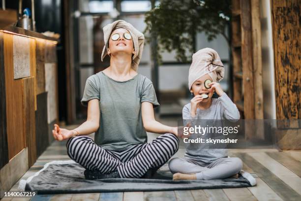 relaxed mother and daughter exercising yoga in the morning at home. - sunday stock pictures, royalty-free photos & images