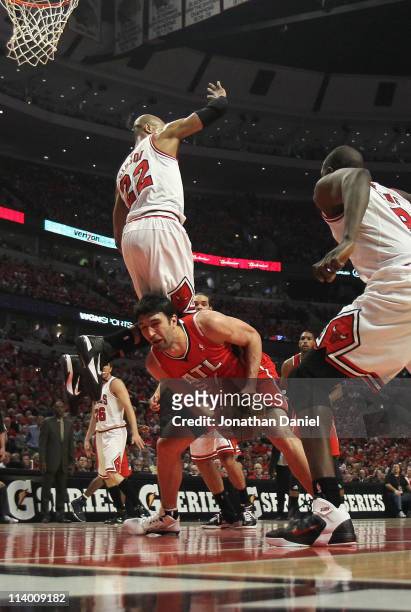 Taj Gibson of the Chicago Bulls falls over Zaza Pachulia of the Atlanta Hawks in Game Five of the Eastern Conference Semifinals in the 2011 NBA...