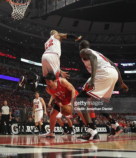 Taj Gibson of the Chicago Bulls falls over Zaza Pachulia of the Atlanta Hawks in Game Five of the Eastern Conference Semifinals in the 2011 NBA...