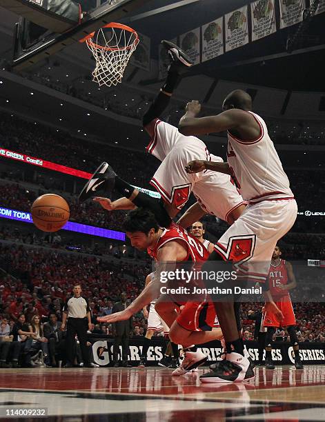 Taj Gibson of the Chicago Bulls falls over Zaza Pachulia of the Atlanta Hawks in Game Five of the Eastern Conference Semifinals in the 2011 NBA...