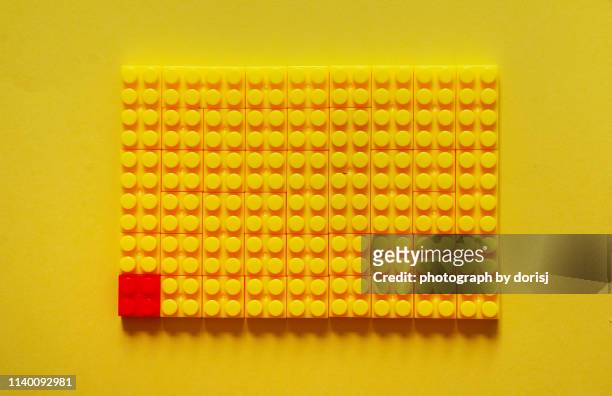 directly above shot of yellow toy blocks and one red color. leadership concept - tetris stock pictures, royalty-free photos & images