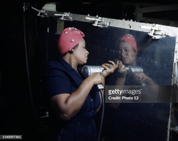 Woman Operates a hand drill at Vultee-Nashville, working on a 'Vengeance' dive bomber, Tennessee October 1942.