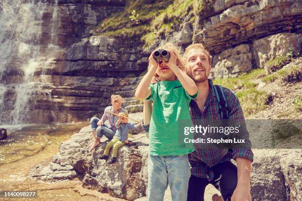 young family exploring beside waterfall - österreich durchblick stock-fotos und bilder