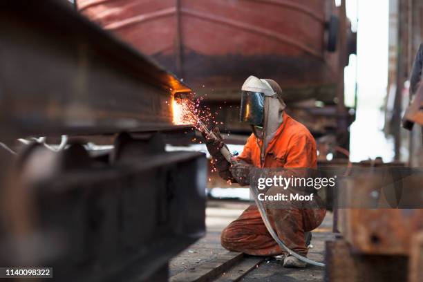 welder welding girder in shipyard workshop - welding stock pictures, royalty-free photos & images