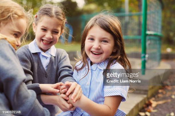elementary schoolgirls playing hand game in school playground - school kids stock pictures, royalty-free photos & images