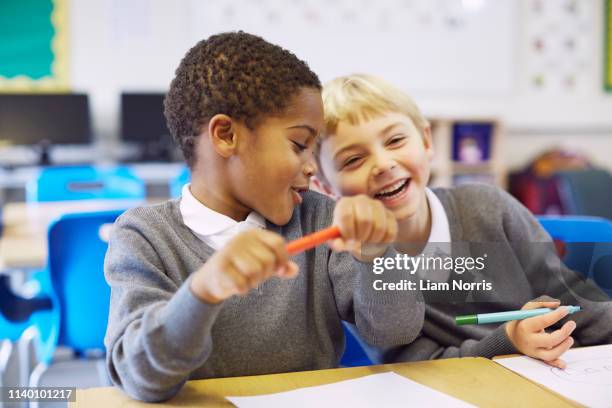 mischievous boys in elementary school classroom - friends prank stock pictures, royalty-free photos & images