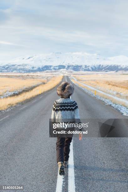 woman walking in middle of country road, iceland - midsection stock pictures, royalty-free photos & images