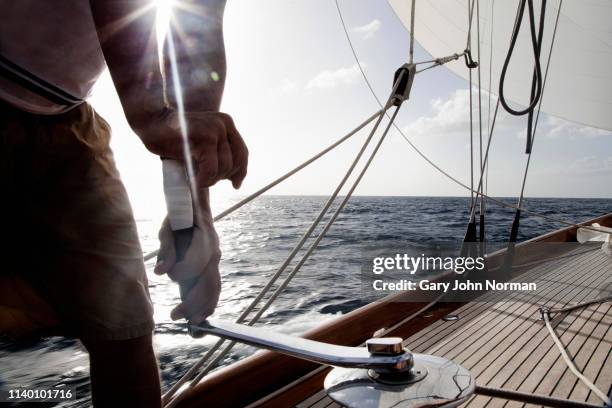 man turning winch handle on classic sail yacht - winch bildbanksfoton och bilder