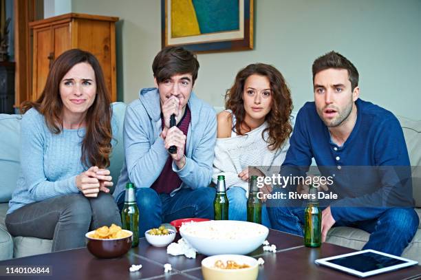 group of friends watching sport in living room - coffee table stock pictures, royalty-free photos & images