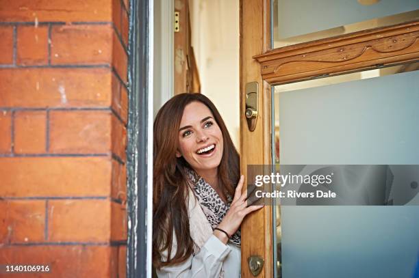 woman opening front door - entrada de casa fotografías e imágenes de stock