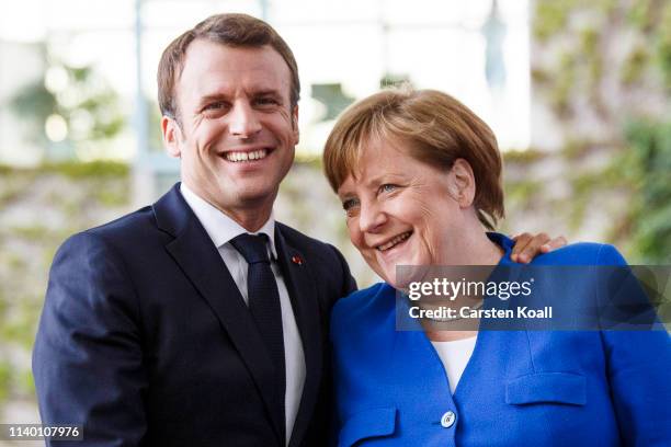 German Chancellor Angela Merkel greets French President Emmanuel Macron upon his arrival at the Chancellery for the Western Balkans Conference on...