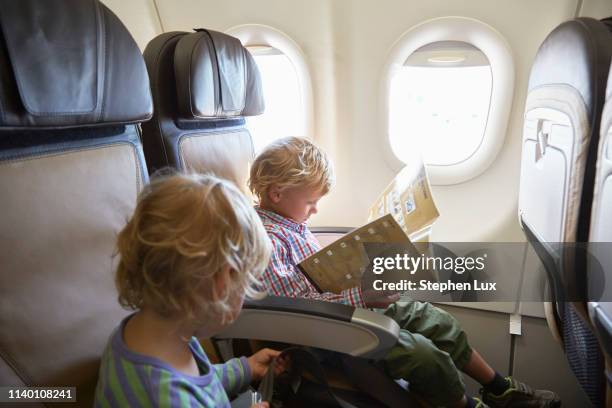 boys seated in airplane - namibia airplane stock pictures, royalty-free photos & images