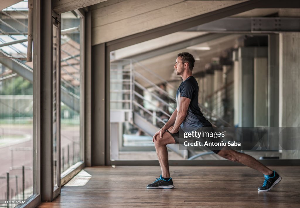 Mid adult man doing lunges