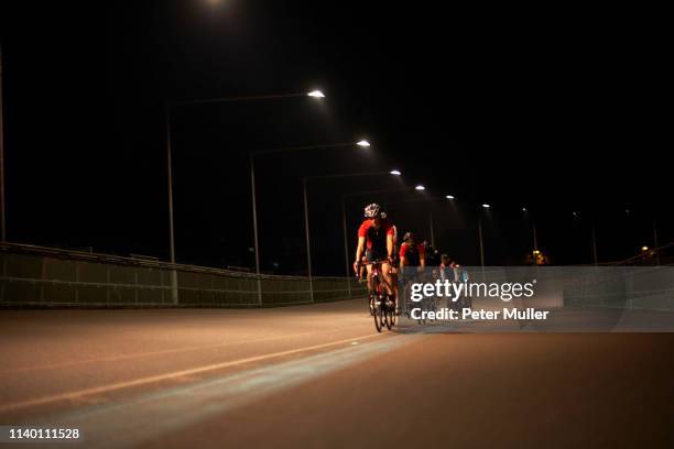 cyclists cycling on track at velodrome, outdoors - fahrrad nacht stock-fotos und bilder
