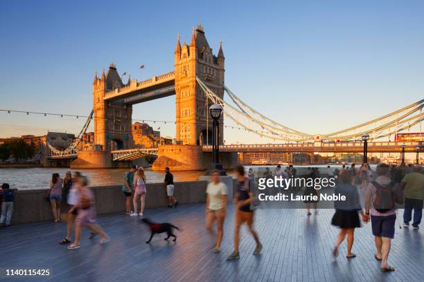 people walking on south bank in front of tower bridge at sunset, london, england, great britain - south bank london stock pictures, royalty-free photos & images