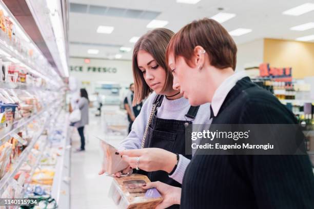 women choosing food beside supermarket refrigerator - sandwich shop stock pictures, royalty-free photos & images