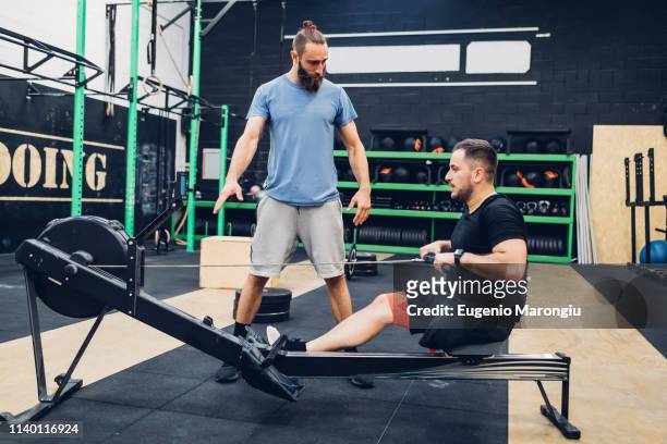 Personal trainer working with man with disability in gym