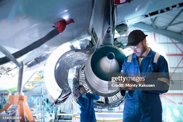 composite image of worker in maintenance factory with digital tablet - aviation worker stockfoto's en -beelden