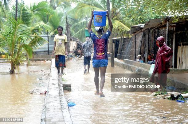 Residents walk in the flooded streets of the Paquite district of Pemba on April 29 as Cyclone Kenneth hit northern Mozambique, killing 38 and...