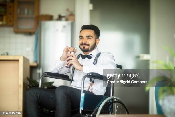 businessman having drink in wheelchair - pensive indian man stock pictures, royalty-free photos & images