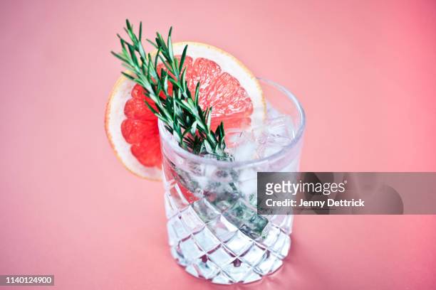 gin and tonic with a slice of pink grapefruit - gin stock-fotos und bilder