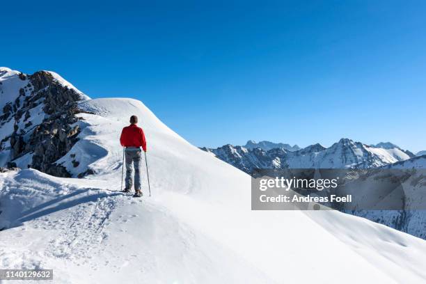 man snowshoeing in the mountains in winter - lech stock pictures, royalty-free photos & images