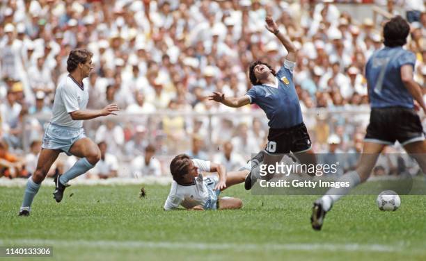 Argentina player Diego Maradona is challenged by England player Terry Fenwick as Kenny Sansom looks on during the FIFA 1986 World Cup quarter-finals...