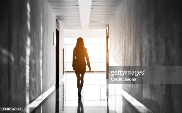 geschäftsfrau durch den bürokorridor - woman walking out door stock-fotos und bilder